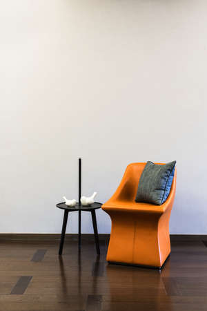 Coffee table Orange Leather chair combination in front of a plain wall
