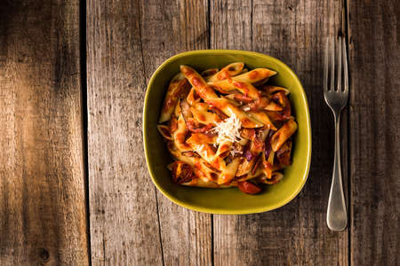 Penne Pasta with Chorizo Creamy Tomato Sauce on Rustic Table Topの写真素材