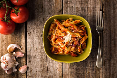 Penne Pasta with Chorizo Creamy Tomato Sauce on Rustic Table Topの写真素材