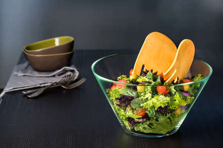 Green salad in glass bowl on a dark tableの写真素材