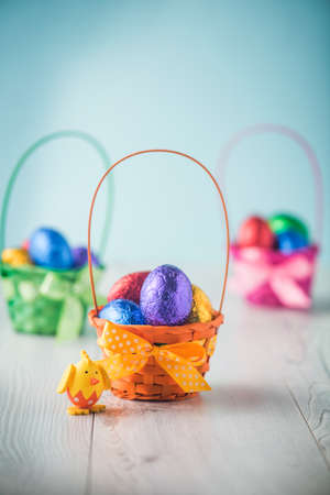 Color full easter eggs in a basket on a white tableの写真素材