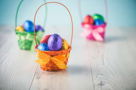 Color full easter eggs in a basket on a white tableの写真素材