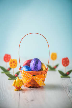 Color full easter eggs in a basket on a white tableの写真素材