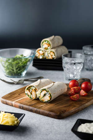 Fresh healthy chargrilled tandoori chicken wrap with tzatziki, cheese, baby spinach and carrotsの写真素材