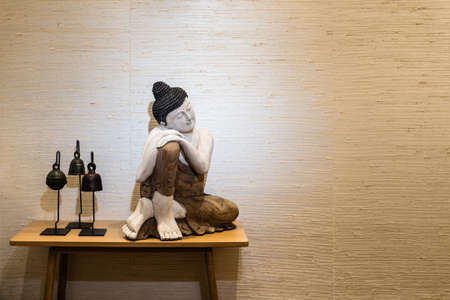 Buddha on a side table in a room with beautiful parquet flooringの写真素材