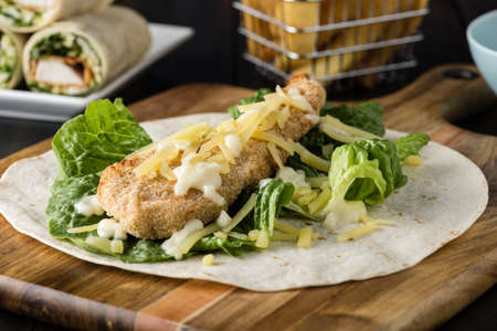 Breaded Chicken burrito Wrap With Fresh Lettuce Cheese on rustic backgroundの写真素材