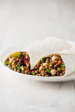 Vegan wraps with lentil, chickpea, kidney bean, peppers and hummus sauceの写真素材