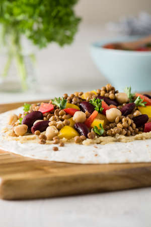 Vegan wraps with lentil, chickpea, kidney bean, peppers and hummus sauceの写真素材