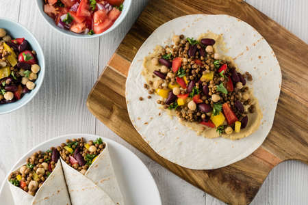 Vegan wraps with lentil, chickpea, kidney bean, peppers and hummus sauceの写真素材
