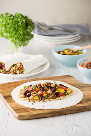 Vegan wraps with lentil, chickpea, kidney bean, peppers and hummus sauceの写真素材
