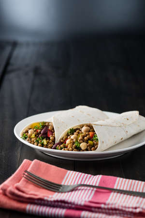 Vegan wraps with lentil, chickpea, kidney bean, peppers and hummus sauceの写真素材