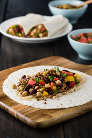 Vegan wraps with lentil, chickpea, kidney bean, peppers and hummus sauceの写真素材