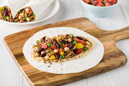 Vegan wraps with lentil, chickpea, kidney bean, peppers and hummus sauceの写真素材