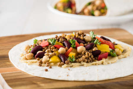 Vegan wraps with lentil, chickpea, kidney bean, peppers and hummus sauceの写真素材