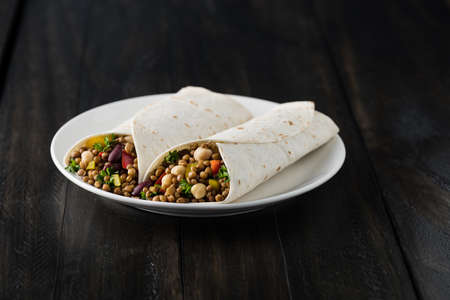 Vegan wraps with lentil, chickpea, kidney bean, peppers and hummus sauceの写真素材