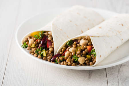 Vegan wraps with lentil, chickpea, kidney bean, peppers and hummus sauceの写真素材