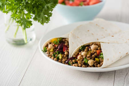 Vegan wraps with lentil, chickpea, kidney bean, peppers and hummus sauceの写真素材