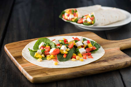 vegan tofu wraps with pepper, corn, tomatoes and spinach