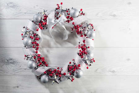 Christmas wreath in red with silver ribbon over plain color backgroundの写真素材