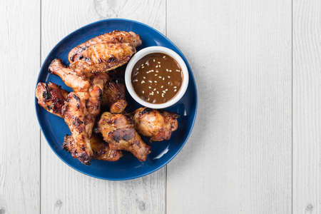 Glazed teriyaki chicken wings with dipping sesame seeds sauceの写真素材