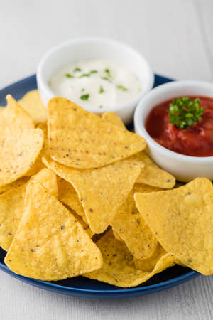 Nachos with salsa and sour cream dipsの写真素材