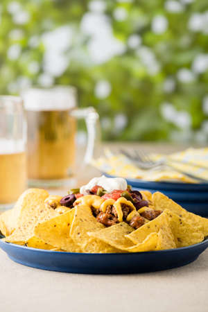 Nachos with beef, jalapeno. beans cheddar cheese and sour cream at beer pub gardenの写真素材