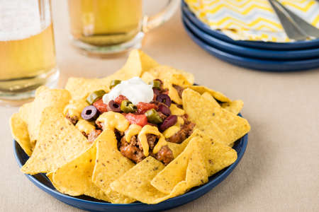 Nachos with beef, jalapeno. beans cheddar cheese and sour cream at beer pub gardenの写真素材