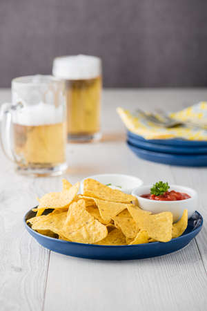 Nachos with salsa and sour cream dips with beersの写真素材