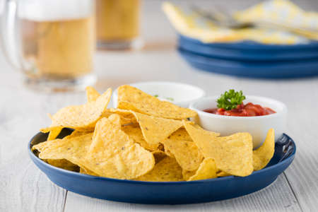Nachos with salsa and sour cream dips with beersの写真素材