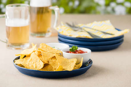 Nachos with salsa and sour cream dips at beer pub gardenの写真素材