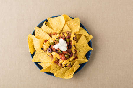 Nachos with beef, jalapeno peppers, olives, tomato, beans, cheese and sour creamの写真素材