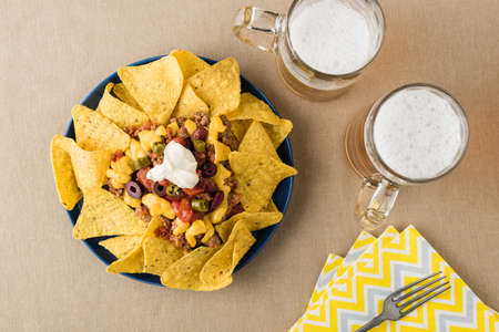 Nachos with beef, jalapeno. beans cheddar cheese and sour cream at beer pub gardenの写真素材