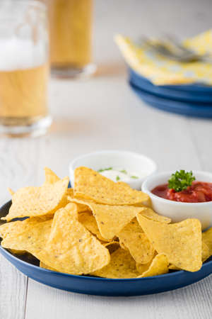 Nachos with salsa and sour cream dips with beersの写真素材