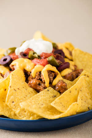 Nachos with beef, jalapeno peppers, olives, tomato, beans, cheese and sour creamの写真素材