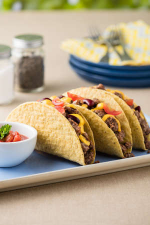 Mexican tacos with beef, cheddar cheese, tomato, beans and salsa dipsの写真素材