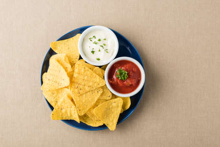 Nachos with salsa and sour cream dipsの写真素材