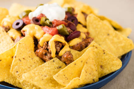 Nachos with beef, jalapeno peppers, olives, tomato, beans, cheese and sour creamの写真素材