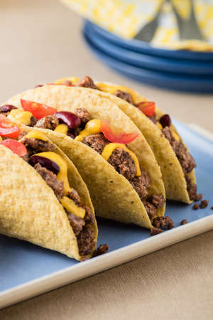 Mexican tacos with beef, cheddar cheese, tomato, beans and salsa dipsの写真素材