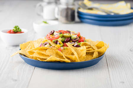 Vegetarian nachos tomato, beans, capsicum, avocado, olive, jalapeno and dipping saucesの写真素材