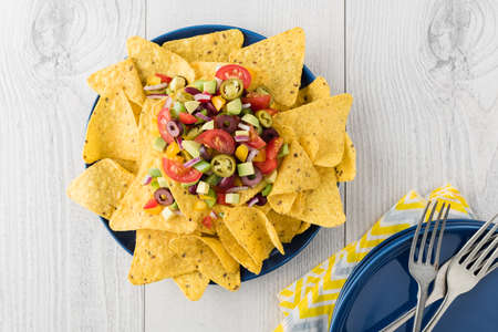 Vegetarian nachos tomato, beans, capsicum, avocado, olive, jalapeno and dipping saucesの写真素材