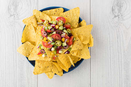 Vegetarian nachos tomato, beans, capsicum, avocado, olive, jalapeno and dipping saucesの写真素材
