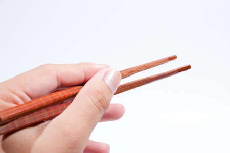Chopsticks are the hand grip. On a white background.の写真素材
