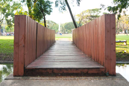 Wooden bridge across the river in the park. Next to the lawn.の写真素材
