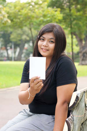Women sitting in the park and hold a white card.
の写真素材