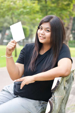 Women sitting in the park and hold a white card.
の写真素材