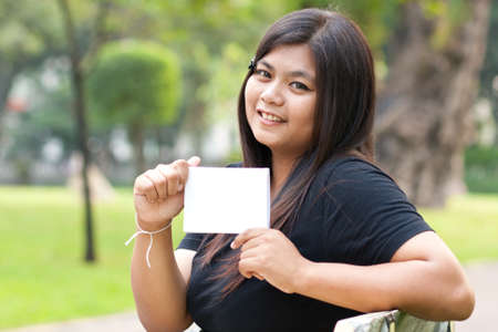 Women sitting in the park and hold a white card.
の写真素材