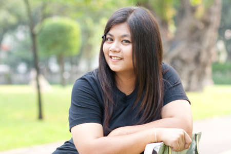 Woman sitting in park smiling towards you.
の写真素材