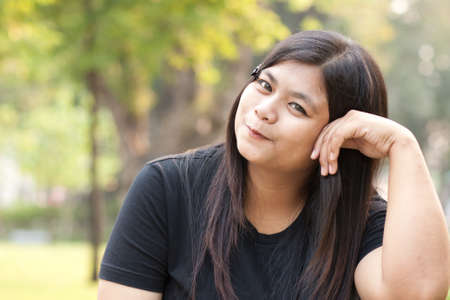 Woman sitting in park smiling towards you.
の写真素材