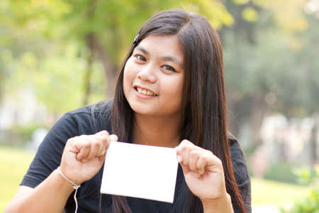 Women sitting in the park and hold a white card.
の写真素材