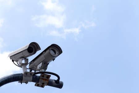 CCTV cameras on high towers in the background sky.